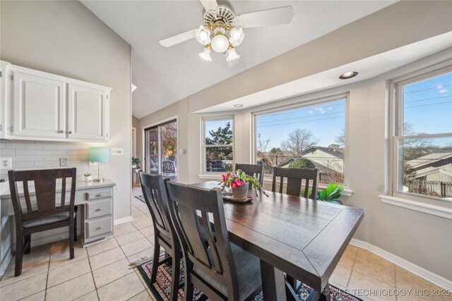 dining area with light tile patterned floors, ceiling fan, baseboards, and lofted ceiling