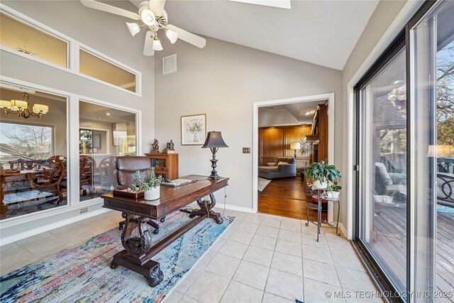 office space featuring light tile patterned floors, ceiling fan with notable chandelier, visible vents, and plenty of natural light