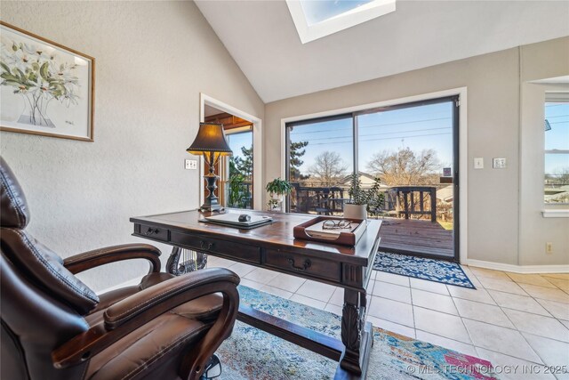 office area with light tile patterned floors, baseboards, and vaulted ceiling with skylight