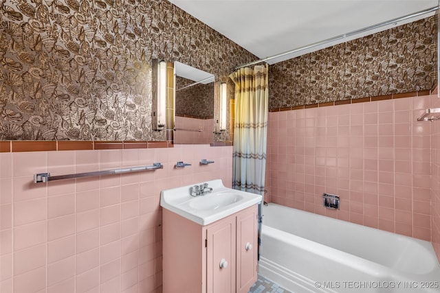 bathroom featuring tile walls, vanity, and shower / bath combo with shower curtain