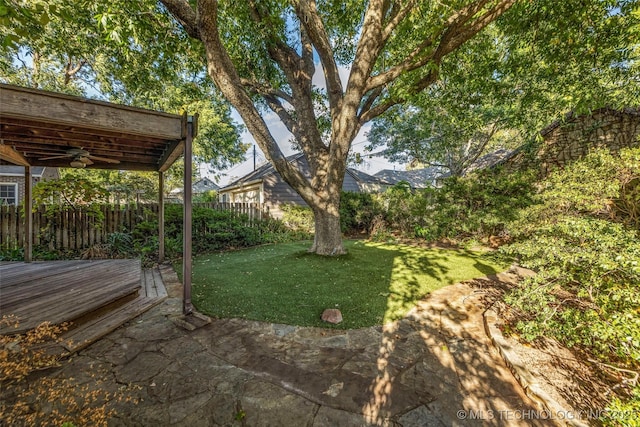 view of yard featuring ceiling fan and a wooden deck