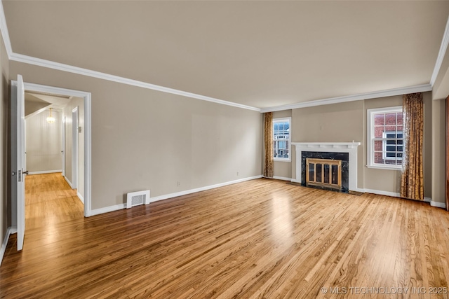 unfurnished living room with light hardwood / wood-style flooring, crown molding, and a fireplace