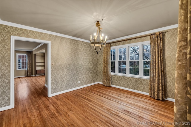 unfurnished dining area featuring hardwood / wood-style flooring, crown molding, and an inviting chandelier