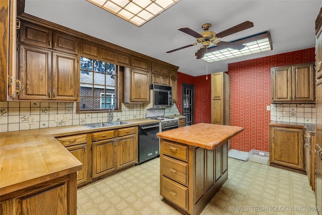 kitchen with butcher block counters, ceiling fan, a center island, black appliances, and sink