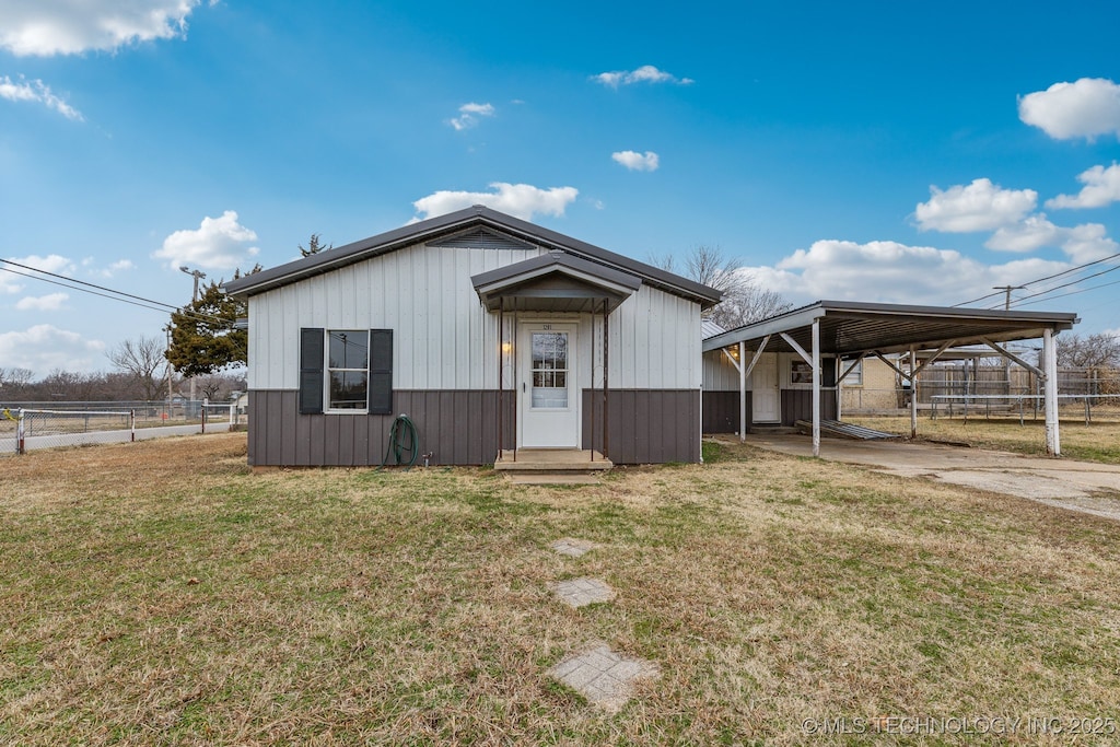 view of front of house with a carport and a front lawn