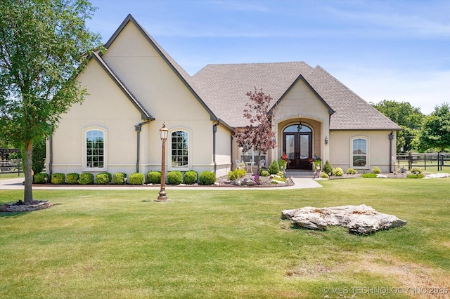 french country inspired facade with a front yard and french doors