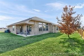 rear view of house featuring a lawn and a patio