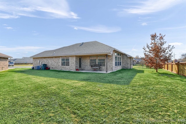 rear view of property featuring a yard, cooling unit, and a patio area