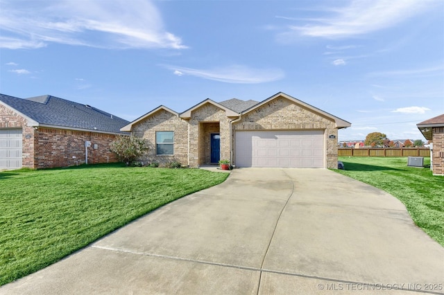 view of front of property with a garage, a front yard, and central air condition unit