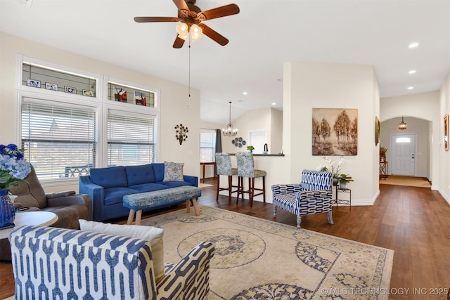 living room with dark wood-type flooring, ceiling fan, lofted ceiling, and plenty of natural light