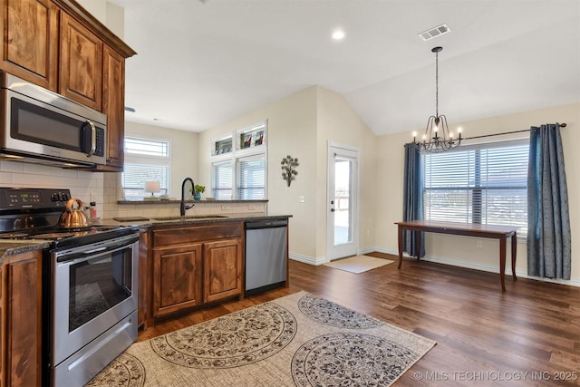 kitchen with appliances with stainless steel finishes, dark hardwood / wood-style floors, sink, and a wealth of natural light