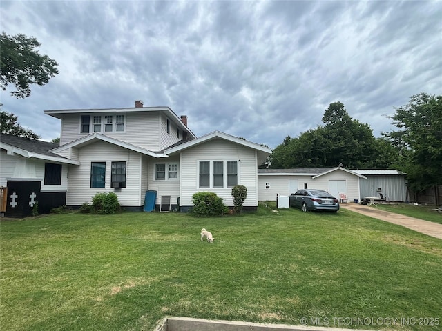 view of front of house featuring a garage, a chimney, and a front lawn