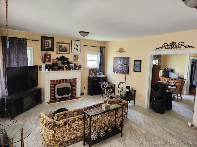 living area featuring a brick fireplace, marble finish floor, and baseboards