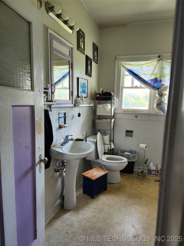 bathroom with tile walls and toilet