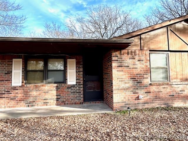 entrance to property featuring brick siding