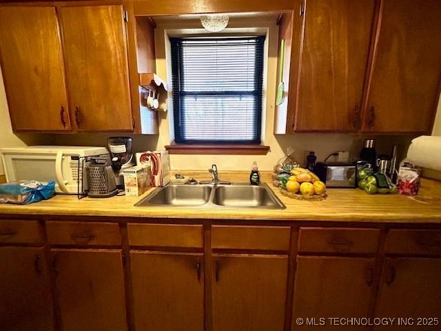 kitchen featuring brown cabinets, light countertops, and a sink