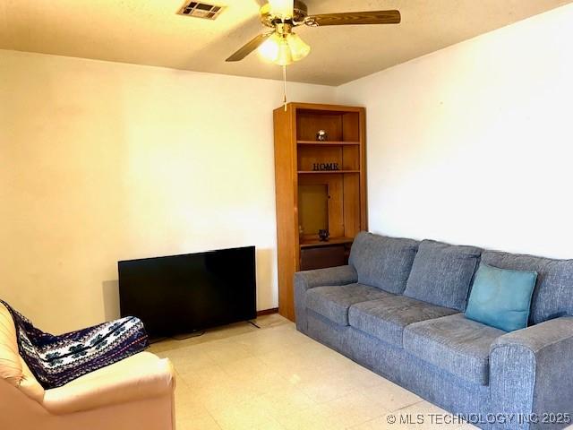 living room featuring a ceiling fan and visible vents