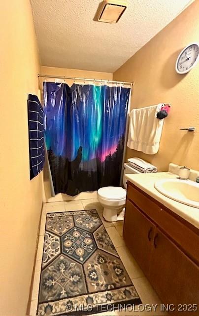 bathroom with a textured ceiling, toilet, visible vents, vanity, and tile patterned floors