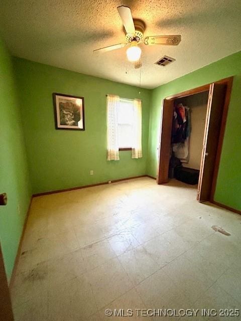 unfurnished bedroom featuring a closet, visible vents, a textured ceiling, and baseboards