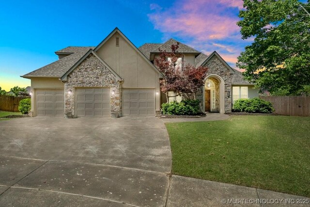 view of front of house featuring a garage and a lawn