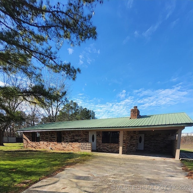 view of front of home with a front lawn and a carport