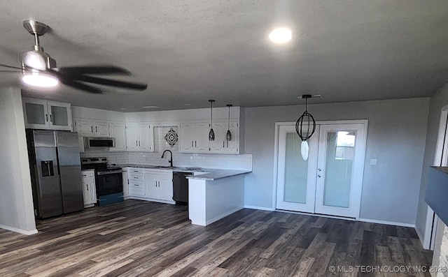 kitchen featuring backsplash, stainless steel appliances, dark wood-type flooring, pendant lighting, and white cabinetry