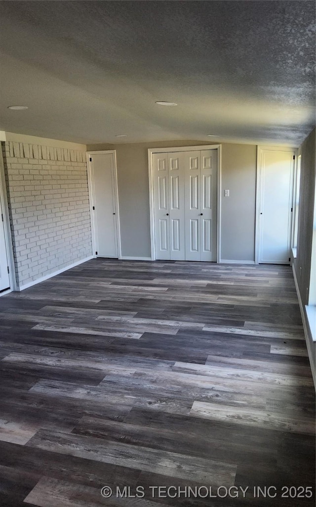 unfurnished bedroom featuring a textured ceiling and dark hardwood / wood-style floors