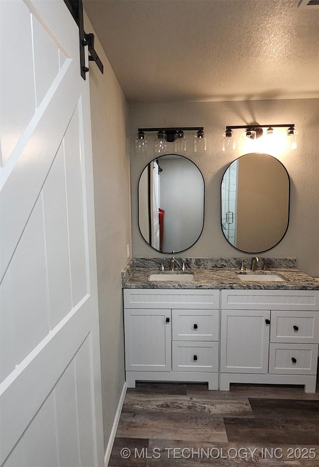 bathroom featuring hardwood / wood-style floors, vanity, and a textured ceiling