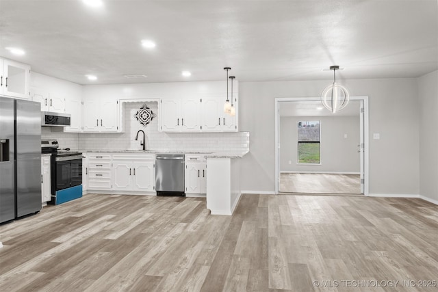 kitchen with appliances with stainless steel finishes, light wood-style flooring, white cabinetry, and tasteful backsplash