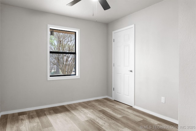 unfurnished room featuring light wood-style flooring, baseboards, and a ceiling fan