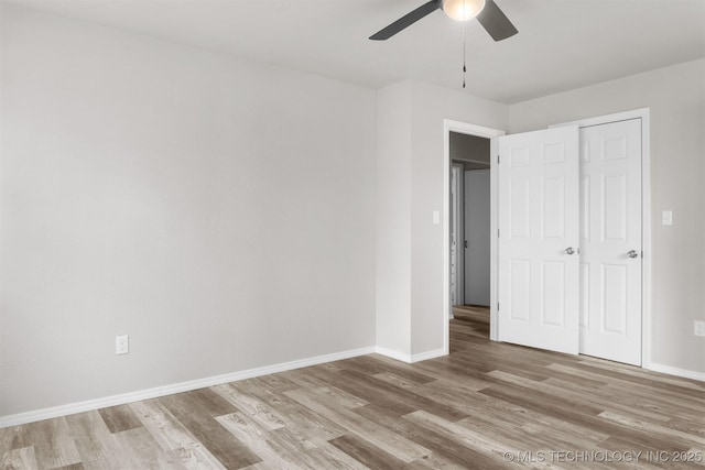 unfurnished bedroom with ceiling fan, light wood-style flooring, and baseboards