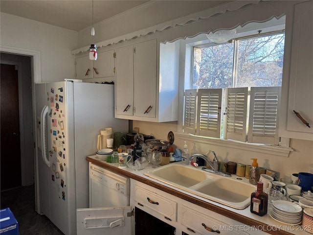 kitchen with white cabinetry, sink, and white dishwasher