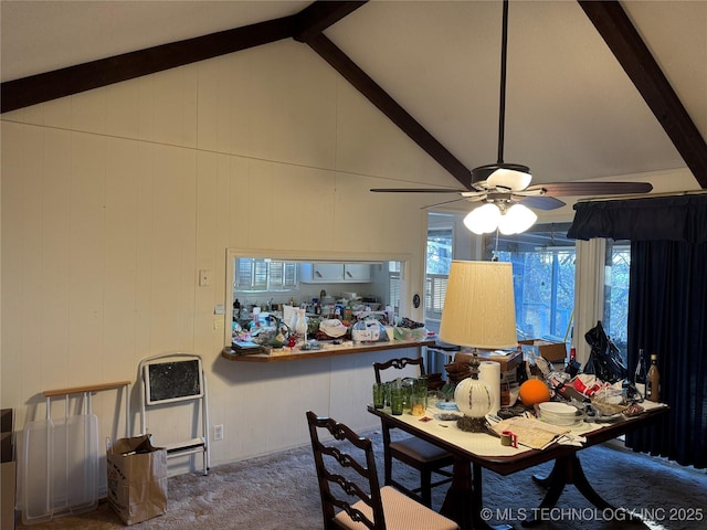 carpeted dining room with plenty of natural light, vaulted ceiling with beams, and wooden walls