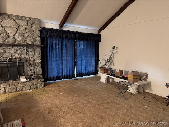 interior space featuring a stone fireplace, carpet, and vaulted ceiling with beams