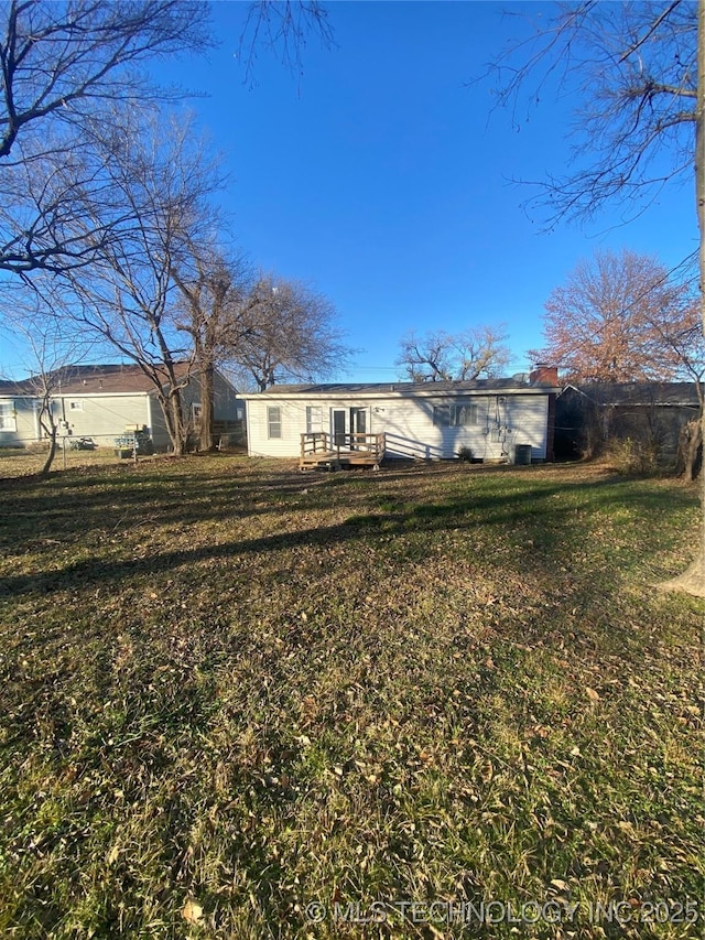 rear view of property featuring a yard