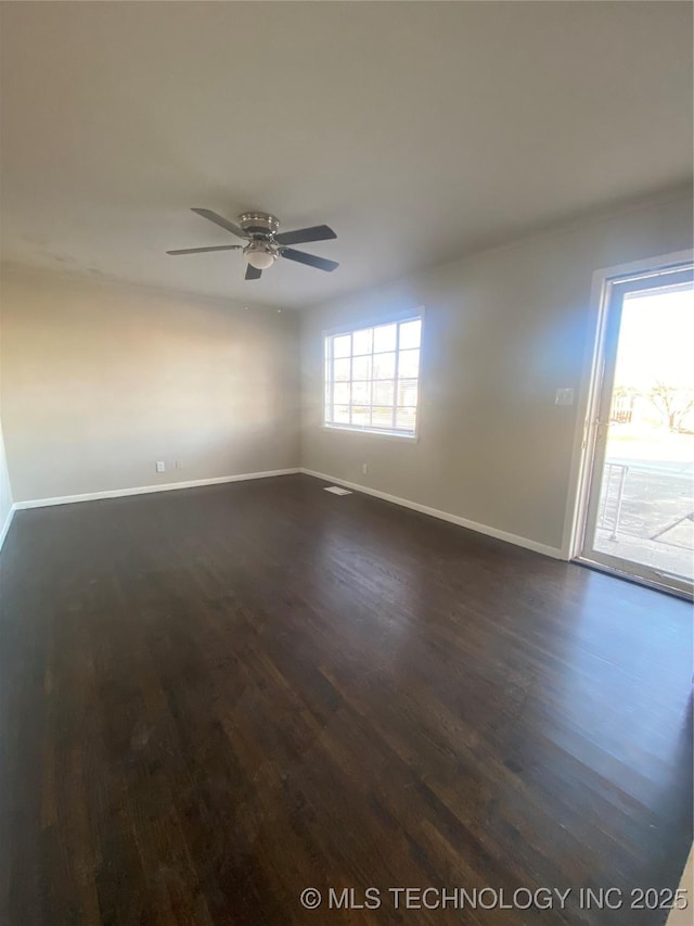 unfurnished room with dark wood-type flooring, ceiling fan, and a healthy amount of sunlight