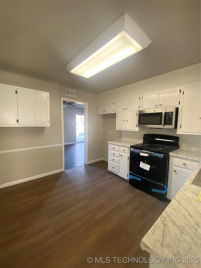 kitchen with black electric range oven, white cabinetry, and dark wood-type flooring