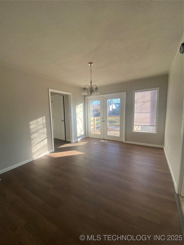 interior space featuring french doors, a textured ceiling, dark hardwood / wood-style floors, and a notable chandelier