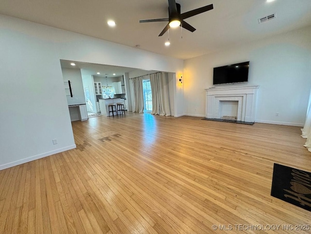 unfurnished living room featuring light hardwood / wood-style flooring and ceiling fan