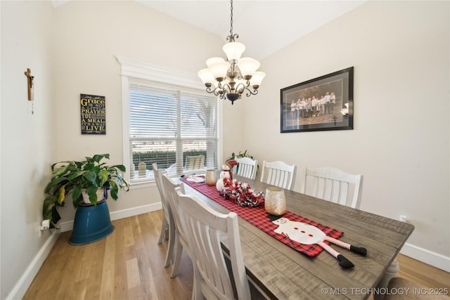 dining area featuring light hardwood / wood-style floors and a notable chandelier