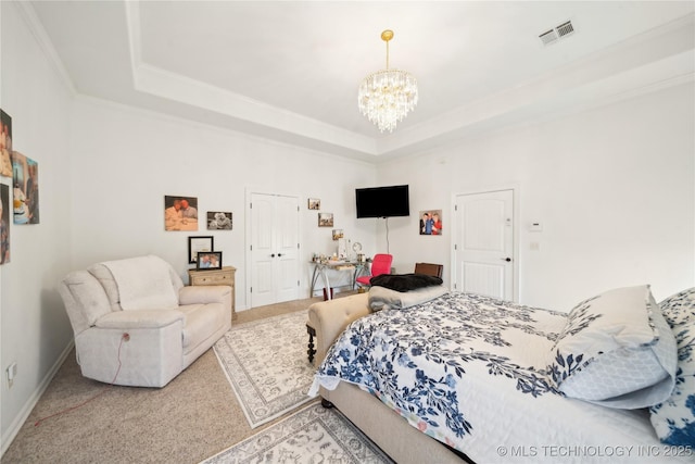 bedroom featuring a tray ceiling, carpet flooring, a chandelier, and ornamental molding