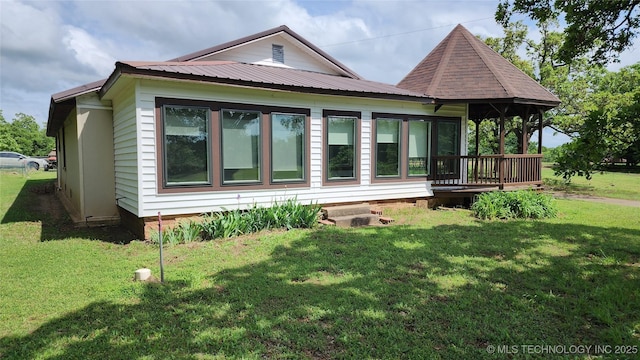 rear view of property featuring a lawn