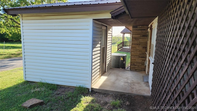 view of side of home with a lawn and central AC