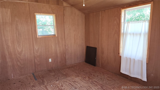 empty room with wood walls and a healthy amount of sunlight