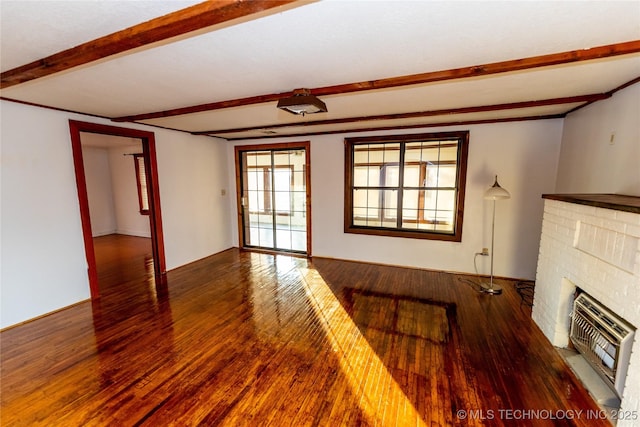 unfurnished living room featuring hardwood / wood-style flooring, a fireplace, beamed ceiling, and heating unit