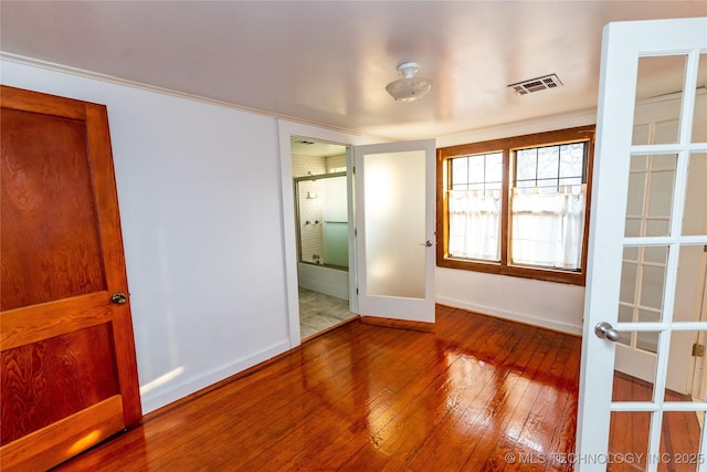 empty room with french doors and hardwood / wood-style floors