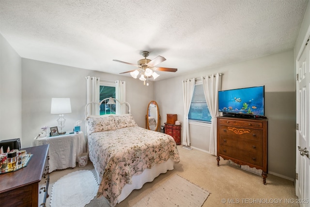 carpeted bedroom featuring ceiling fan and a textured ceiling