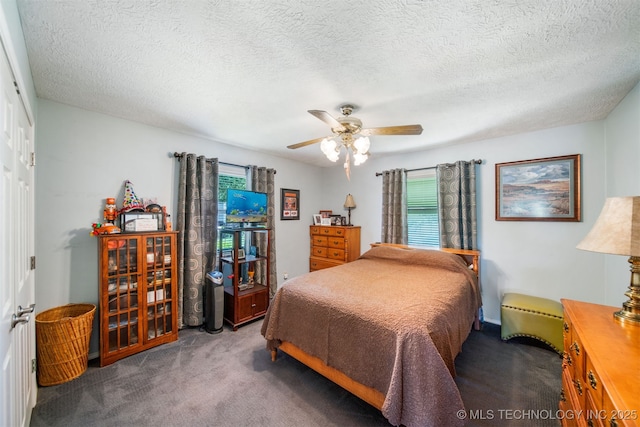 carpeted bedroom with ceiling fan, a textured ceiling, and a closet