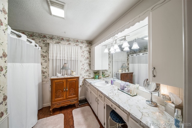 bathroom with hardwood / wood-style floors, vanity, and a textured ceiling