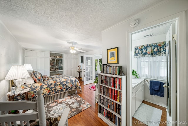 bedroom featuring ceiling fan, a textured ceiling, and hardwood / wood-style flooring